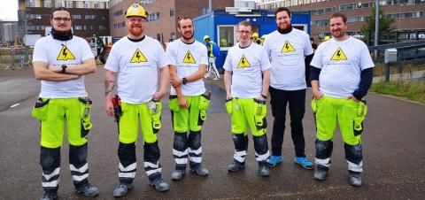 Gruppe af elektrikere i t-shirts fra kampagnen Følger efter elulykker